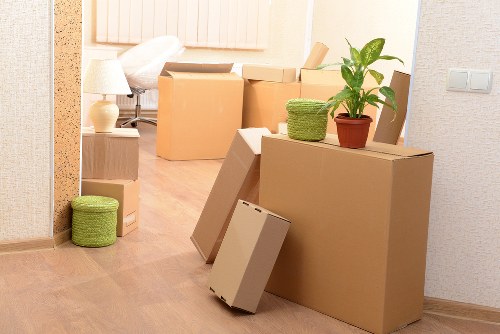 Movers carrying furniture through a flat entrance in Hampton Wick