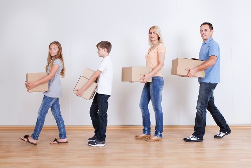 Moving team transporting furniture through a residential street in Hampton Wick